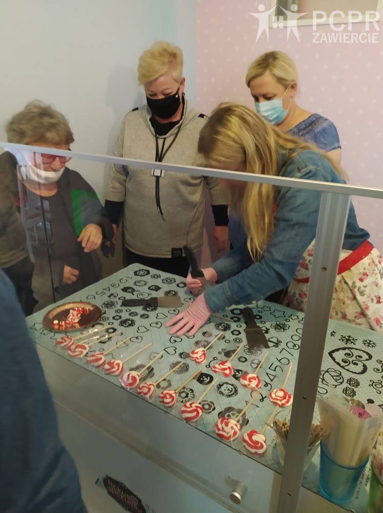 Zdjęcie: Grupa kobiet foruje szpachelkami słodycze na szablonie z wzorami